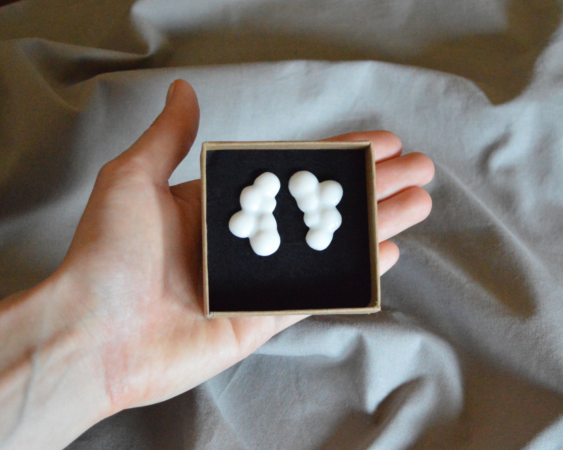Light porcelain earrings in shapes of clouds